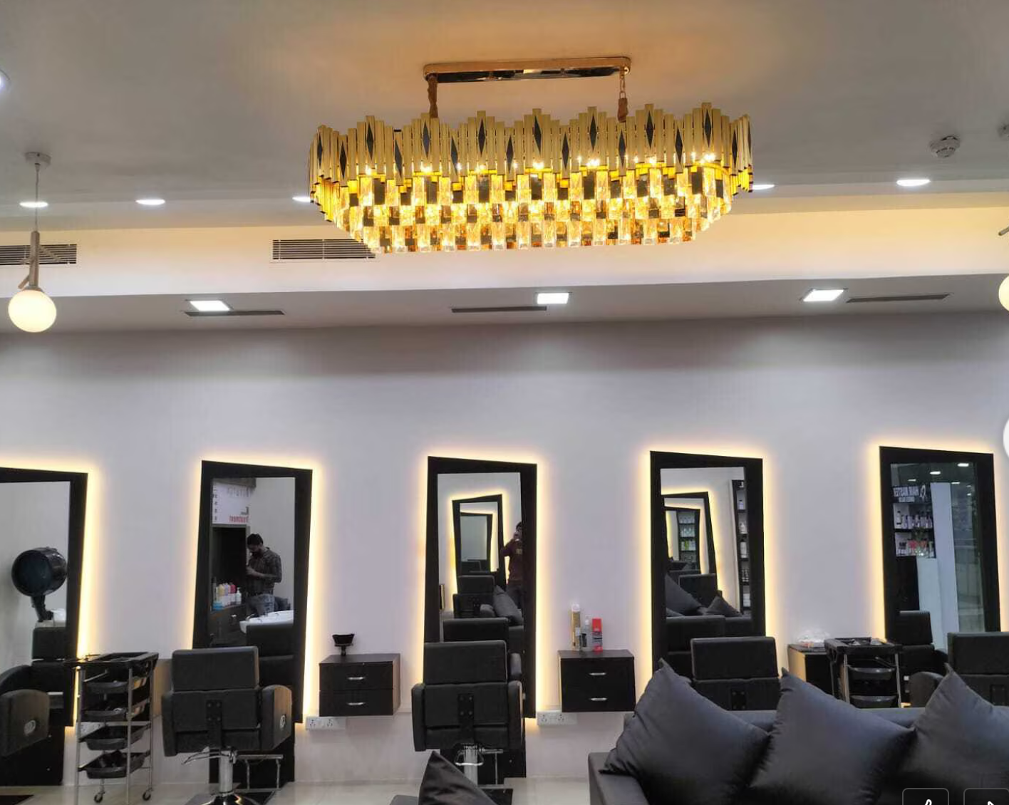 Interior of The Hair Master Unisex Salon in Kharghar with gold chandelier and styling mirrors